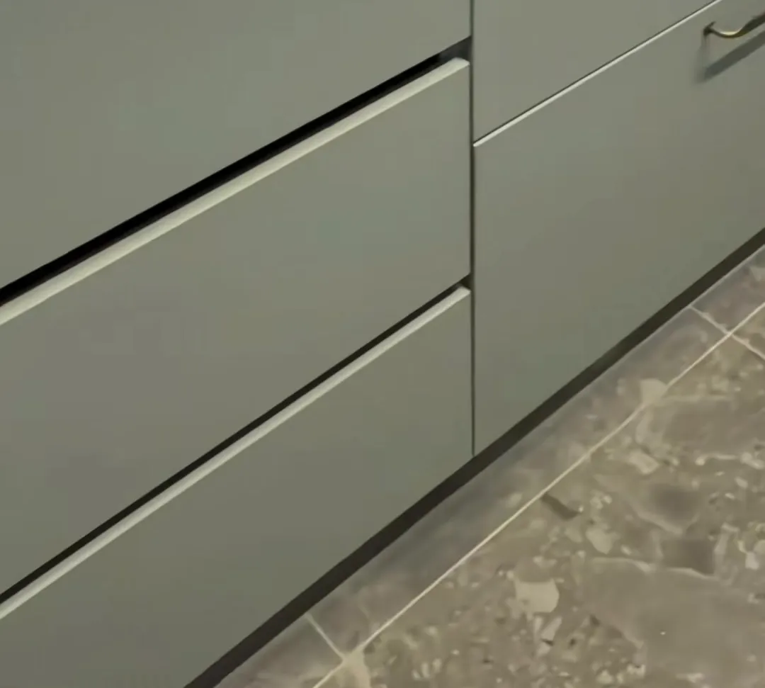 Cocina renovada en Las Condes con muebles verde salvia y cubierta de cuarzo blanco