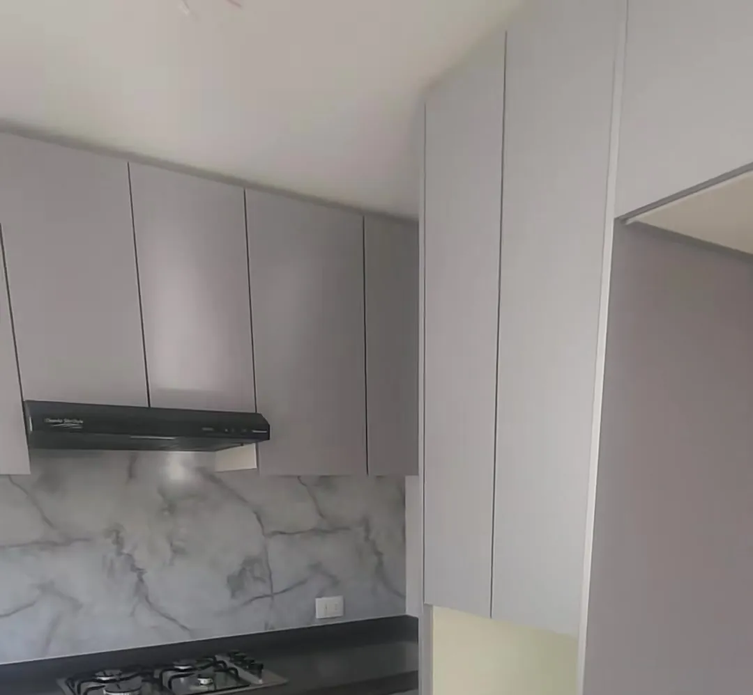 Cocina renovada en Ñuñoa con mobiliario gris y lámina marmoleada