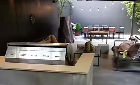 Mini quincho construido con parrilla a gas empotrada y cubierta de madera